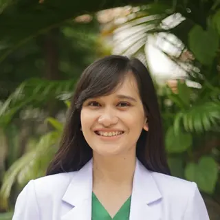 Daniela C., cuidadora del aviario, con bata blanca en el jardín (foto de ejemplo)