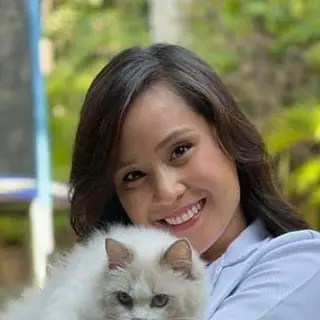 Marisol R., cuidadora de felinos, con un gato en brazos (foto de ejemplo)